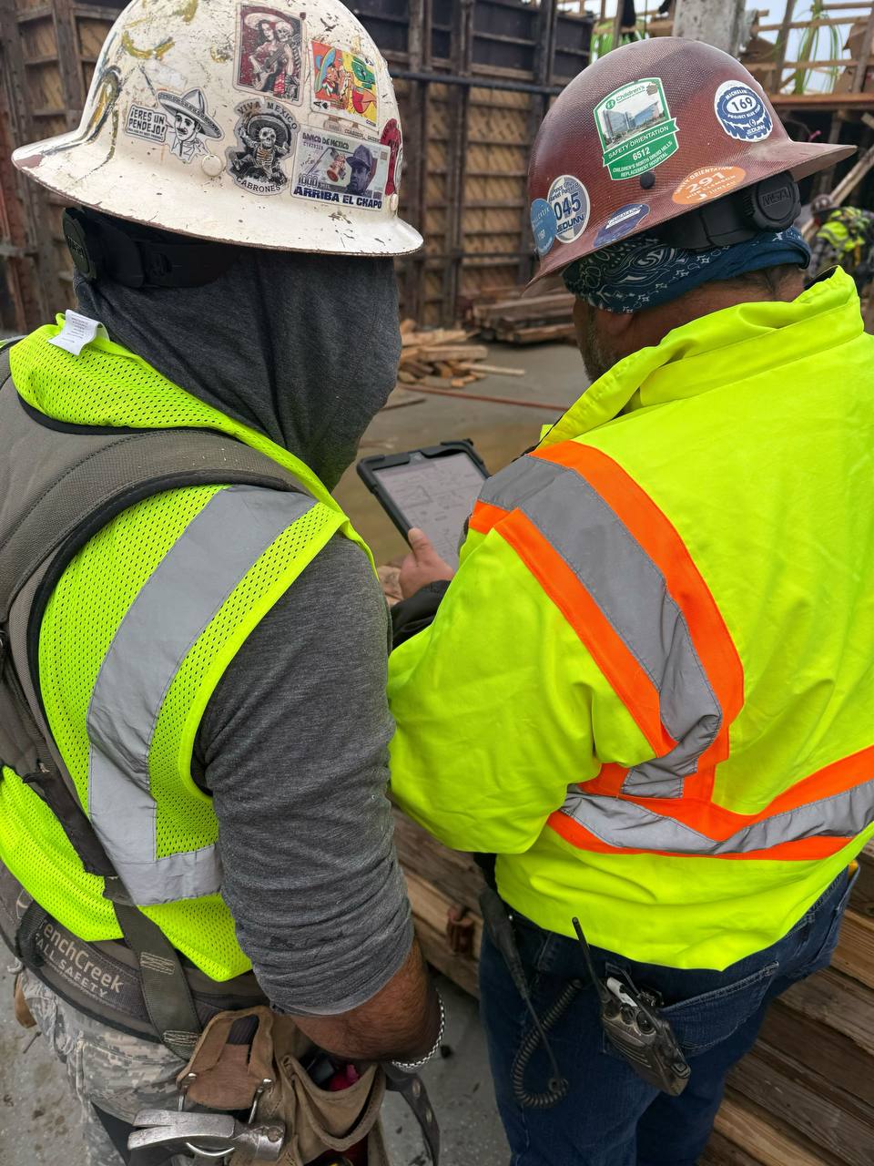 Crew reviewing plans on a tablet at a construction site