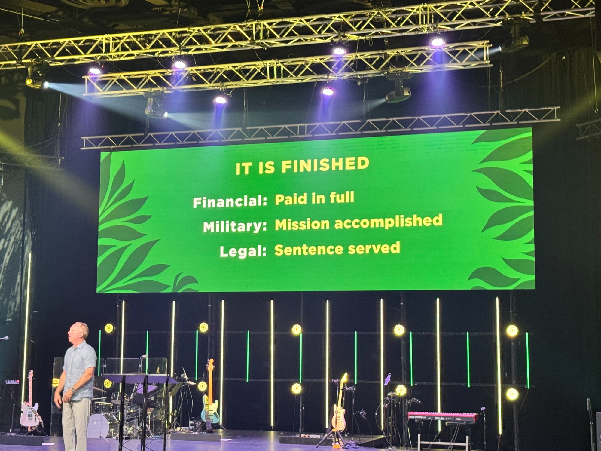Pastor Mac Richard teaching at Lake Hills Church Easter service with It Is Finished slide showing financial military and legal meanings of tetelestai